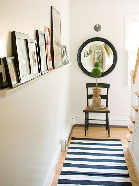 Give those who are passing through hallways something worth observing. Hang a long shelf deep enough to hold propped-up family photos and colorful artworks but shallow enough that the shelf won't intrude too far into the passageway. Look for ledgelike shelves that feature routed grooves designed for keeping propped items steady and in place. In passageways, go with narrow shelves so they are less likely to be bumped into. Long Narrow Hallway Decorating, Picture Wall Living Room, Narrow Shelves, Narrow Hallway Decorating, Pantry Shelving, Deep Shelves, Long Shelf, Narrow Hallway, Built In Bookcase