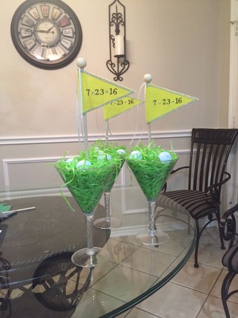 Golf Bay Table Centerpieces - FRONT Plastic Martini Glasses.  Hot glue flower foam cone in center to stick flag in to.  Fill with bags of "Easter" grass and several golf balls on top.  We used felt to make the flags, dowels, and dowel toppers that we glued in place. Masters Golf Party Centerpiece, Golf Table Decorations Simple, Golf Party Decorations Diy Table Centerpieces, Golf Tournament Table Centerpieces, Golf Flags For Centerpieces, Golf Themed Centerpieces Flower, Golf Table Decorations, Golf Tournament Gifts, Golf Centerpieces