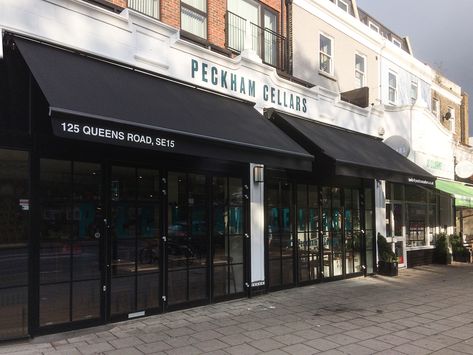 These large Classic folding awnings with their robust construction have been powder coated by us, in our own workshop, in black to blend in with the shopfront surround at Peckham Cellars Wine Bar soon to be open  on the Queens Road in Peckham. Candle Store Interior, Retail Exterior, Black Awning, Commercial Awning, Shop Awning, Gear Mechanism, Minimal Classic Style, Custom Awnings, Metal Awning