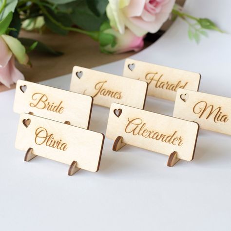 Laser cut and engraved Wooden name tags for your event table. A great wedding table decor, place marker and a small personalised gift for your guest, as the word sign will serve as a keyring after the party. You can order name tags with or without holders and in plain wood with laser engraved names or dark brown colour with white printed names. You can choose your own font style if needed. Size for name tags: 3 x 1,1 Inches or 8x3 cm How to order: 1. Choose colour and style 2. Choose quantity 3. Laser Cut Wedding Decor, Laser Wedding Ideas, Wood Wedding Table Numbers, Laser Cut Gifts, Wooden Name Tags, Laser Engraved Wedding, Wedding Name Tags, Wood Laser Ideas, Gift For Guests