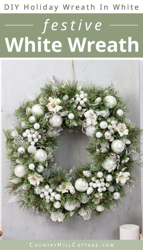 Bring holiday spirit to your home and see how to make a white Christmas wreath! Homemade holiday wreaths are a wonderful seasonal craft. This all-white wreath features muted winter shades with sparkly baubles, frosted ornaments, silk flowers, and touches of silver-grey sprigs. The homemade holiday wreath is perfect for adorning your front door and walls and hanging over the mantle. You can pair white with an accent color like gold, red, black, blue, purple, or green. | CountryHillCottage.com Christmas Wreath Frosted, White Christmas Wreaths For Front Door, Frosted Ornaments, Giant Christmas Wreath, Disney Wreath, Bauble Wreath, White Christmas Wreath, Marshall University, Silver Christmas Decorations