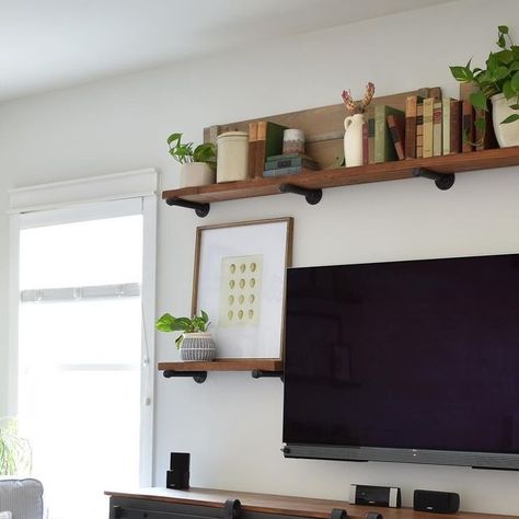 Lindsey Joy on Instagram: "That shelf above the TV is one of the trickiest places to decorate but I’m really loving the plant/book combo I came up with for spring. #dreamingaboutdecorspring04" Book Shelf Above Tv, Long Shelf Over Tv, Shelving Above Tv, Bookshelf Above Tv, Wall Shelves Above Dresser, Shelbes Above Tv, Plant Shelves Around Tv, Long Shelf Above Tv, Plant Shelf Above Tv