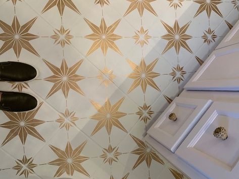 I didn’t care for the marbled gray look of the builder grade ceramic tile in this guest bathroom so I painted it.I previously painted my laundry room floor a year ago so I decided it was time to do this floor too.I wanted something different so I went with the gold and it just made the room. Now I love it!   Stenciling can be tedious but it’s rather rewarding in the end.   Below I will tell you the steps I took!First I cleaned the floor really well with Krud Kutter.   Next, I primed th… Gold Bathroom Floor Tile, Builder Grade Bathroom Makeover, Hemlock Tattoo, Painted Tile Floor, Builder Grade Bathroom, Diy Vanity Lights, Painted Bathroom Floors, Bathroom Makeover On A Budget, Star Bathroom