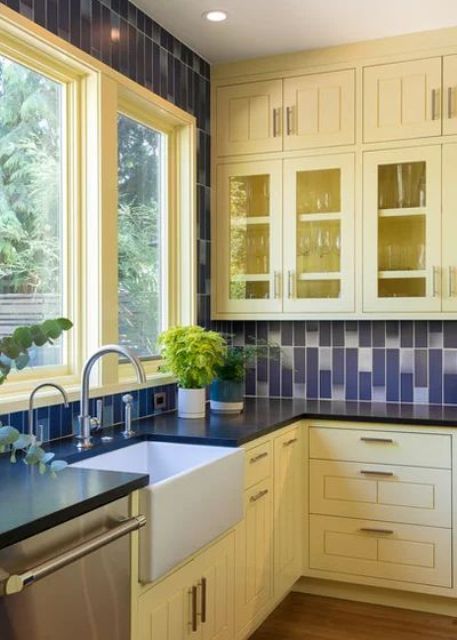 a traditional yellow and navy kitchen with navy and white tiles on the wall and backsplash Pale Yellow Kitchens, Blue Yellow Kitchens, Yellow Kitchens, Heath Ceramics Tile, Yellow Kitchen Cabinets, Open Kitchen Cabinets, Blue Kitchen Designs, Yellow Cabinets, Navy Kitchen