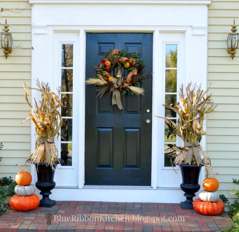 This fall porch with stacked pumpkins and corn stalk filled urns offers a friendly autumn welcome without being too fussy or requiring too much effort. Corn Stalk Decor, Fall Urn, Outside Fall Decor, Easy Fall Wreaths, Corn Stalks, Fall Front Porch Decor, Halloween Front Porch, Stacked Pumpkins, Fall Front Porch