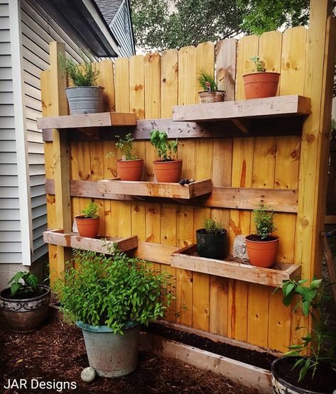 If you don't have a lot of space for gardening or pots, try building shelves on the back side of a fence. By doing this, I was able to have all my favorite herbs within an arms reach. Make sure to stagger your shelves for easy watering. Garden Fence Shelves, Garden Wall Shelves, Shelves On Fence, Outdoor Wall Herb Garden Ideas, Fence Flower Pots, Outdoor Fence Shelves, Fence Shelves, Diy Fence Planters, Garden Shelves Outdoor