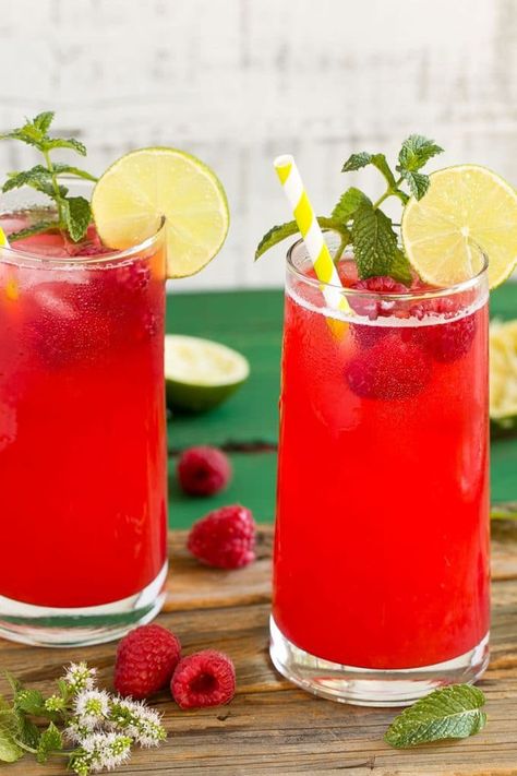 Glasses of raspberry limeade garnished with mint and limes. Raspberry Limeade, Raspberry Juice, Raspberry Lemonade Punch Non Alcoholic, Raspberry Lime Rickey, Raspberry Lemonade Mocktails, Sparkling Raspberry Lemonade, Summer Punch Recipes, Raspberry Drink, Limeade Recipe