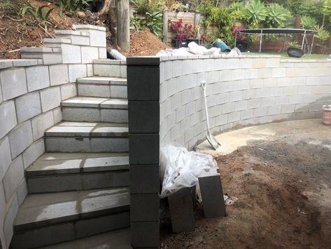 Curved concrete block retaining wall with steps Block Retaining Wall With Steps, Allen Block Retaining Wall, Cinder Block Retaining Wall, Casino Exterior, Curved Retaining Wall, Concrete Garden Wall, Tiered Backyard, Basement Egress, Concrete Block Retaining Wall