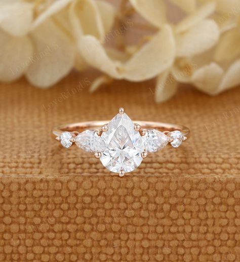 Pear shaped moissanite engagement ring Unique vintage Rose gold engagement ring Cluster diamond wedding ring Bridal Promise Anniversary gift ITEM DESCRIPTION: Center stone:l Moissanite Size:6*8mm Shaped: Pear cut Side stone: 0.28ct moissanite  or diamond Color/Clarity: E-F,SI1-VS Width of band: 1.6mm Thickness of band: 1.2mm Total weight: 2.3g Materials (can select from drop-down menu): 14K Solid gold/ 18K Solid gold ( Rose gold, Yellow gold, White gold) Size: all ring sizes are available, pleas Moissanite Pear Engagement Ring, Gold Pear Engagement Rings, Unique Engagement Rings Rose Gold, Pear Moissanite Engagement Ring, Rose Gold Moissanite Ring, Moissanite Engagement Ring Rose Gold, Rose Gold Engagement Ring Vintage, Engagement Rings Twisted, Ring Cluster