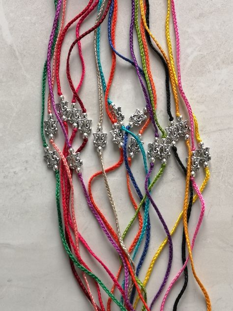 Colourful Ganedh rakhi's with silver embellishments Aesthetic Rakhi Ideas, Rakhi Designs 2024, Latest Rakhi Designs Handmade, Aesthetic Rakhi, Rakhi Designs Handmade, Crochet Rakhi, Knitting Yarn Diy, Rakhi 2024, Silver Rakhi