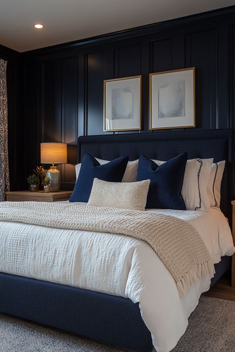 Create a cozy and chic navy blue and gold bedroom with these 29 stunning ideas.  Explore the versatility of this color combination to create a space that feels both inviting and luxurious.  Discover stunning decor ideas like navy velvet headboards, gold-framed mirrors, and brass light fixtures.  Add navy and gold throw pillows, gold geometric wall art, and plush navy carpets for a cozy and stylish bedroom oasis. Navy Spare Bedroom, Navy Bed Decor, Midnight Blue Room Decor, Blue And Brass Bedroom, Navy Blue Wall Paneling Bedroom, Bedroom Navy Headboard, Dark Navy Master Bedrooms Decor, Bedrooms With Navy Accent Wall, Navy Blue Wall Bedroom Ideas