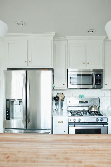 Cabinets, kitchen, refrigerator next to range, built in cabinets, small kitchen Fridge Next To Stove Kitchen Layouts, Regency Kitchen, Farmhouse Stove, Small Kitchen Inspiration, Manhattan House, Stove Vent, Best Kitchen Lighting, Small Stove, Small Bungalow