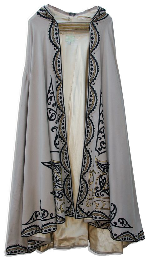 This beige woven cape is decorated with an embroidered design in black and gold thread running around the hemline, up the front and extending around the pointed hood, which culminates in a tassel. Cloak is fully lined in champagne silk. Worn by Anthony Quinn in Road To Morocco (1942) Celtic Ren Faire, Classic Movie Costumes, Cloak Ideas, Embroidered Cloak, Silk Costume, Sergio Toppi, Bracelet Weaving, The Beast Costume, Beauty And The Beast Costume