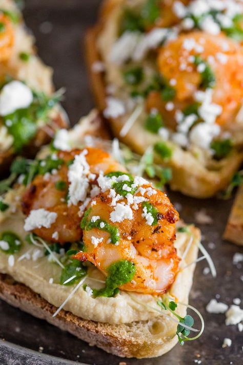 This cajun shrimp hummus crostini is the perfect summer appetizer. Toasted bread topped with hummus, microgreens, shrimp, cilantro pesto and feta cheese. Hummus Crostini, Chipotle Shrimp Tacos, Chipotle Shrimp, Cajun Shrimp Recipes, Crostini Appetizers, Cilantro Pesto, Crostini Recipes, Easy Chicken Dinner Recipes, Toasted Bread