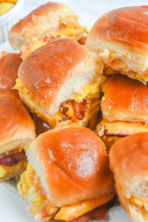 The easy Hawaiian Roll Breakfast Sliders are filled with fluffy scrambled eggs, crispy bacon, and melty cheese. The soft, sweet rolls are drizzled with maple butter and then baked to perfection! Bacon Egg And Cheese Sliders, Egg And Cheese Sliders, Hawaiian Roll Breakfast Sliders, Hawaiian Roll Breakfast, Slider Recipe, Breakfast Sliders, Cheesesteak Sliders, Philly Cheese Steak Sliders, Hawaiian Roll