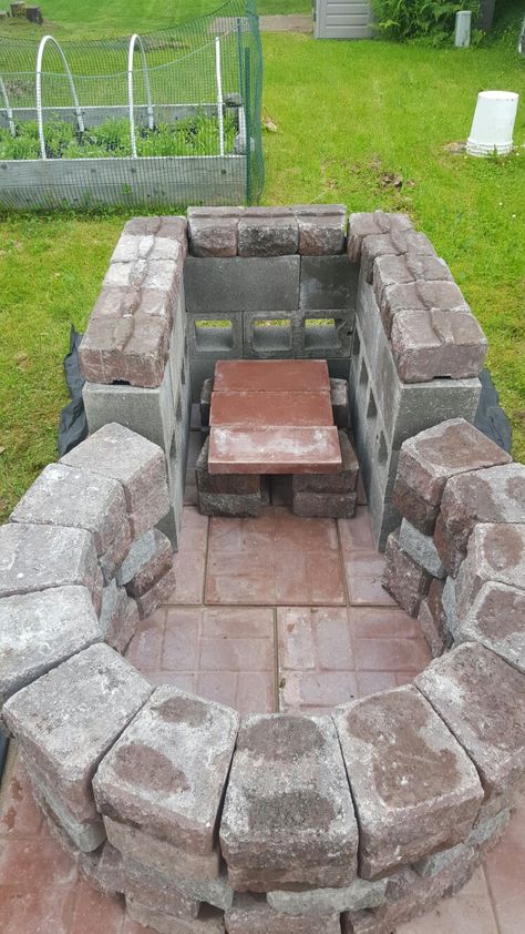 Keyhole fire pit with grilling area.   4 foot circle, outside diameter, with ~3 foot square raised grilling area.  Cinder blocks, pavers, and retaining wall bricks. Keyhole Fire Pit Ideas, Keyhole Fire Pit, Retaining Wall Bricks, Outdoor Fire Pit Seating, Grilling Area, Gazebo With Fire Pit, Outside Fire Pits, Fire Pit Cooking, Brick Fire Pit