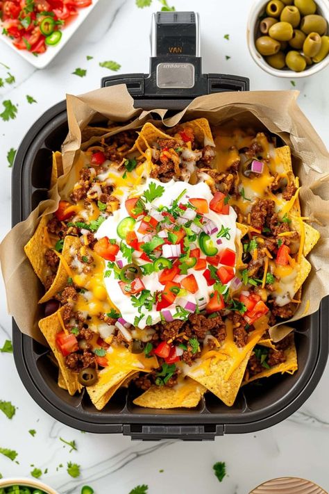 Grab these easy air fryer nachos while they’re hot! Between the taco-licious ground beef, juicy tomatoes, and gooey cheese, they’re not to be missed. Best Cheese For Nachos, Air Fryer Nachos, Ground Beef Nachos, How To Make Nachos, Loaded Nachos, Air Fryer Recipe, Nachos Beef, Yummy Healthy Snacks, Nachos Recipe