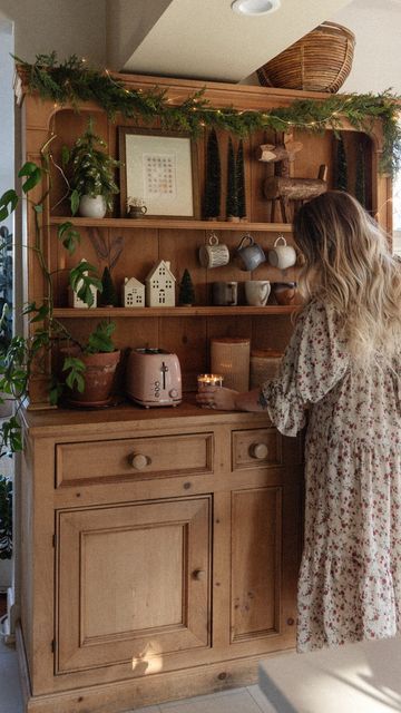 shyla cino on Instagram: "Jazzing up the coffee hutch for the holidays🥹🎄 . . . . . . #holiday #holidaydecor #christmasdecor #garland #hutch #coffeebar #coffeebardecor #kitchendecor #vintagefurniture vintage antiques styling Christmas holiday decor home interiors hutch" Natural Wood Kitchen Hutch, Wallpaper In Hutch, Cottage Hutch Decorating Ideas, Hoosier Cabinet Christmas Decor, Vintage Living Room Ideas Antique, Vintage Hutch In Kitchen, Vintage Christmas Home Decor, Styling A Hutch Dining Rooms, Vintage Christmas Kitchen Decor