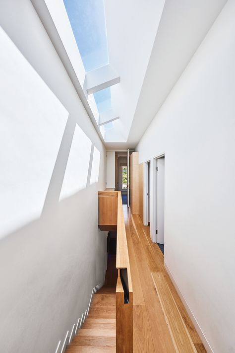 Long, narrow skylights illuminate the American oak timber stairs, where a discreet hand-hold is crafted into the joinery. The laundry is hidden in cabinetry at the end of the hallway – an ironing board folds out on the left, Skylight Entrance, Skylight Entrance Hall, Skylight In Hallway, Narrow Skylight, Floor Skylight, Skylights Ideas Ceilings, Skylights Ideas, Skylight Design, Sky Lights