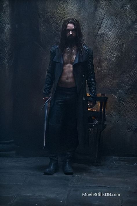 Young Michael Sheen in costume as Lucian. He’s wearing a leather outfit that includes black leather trousers and open jacket, with no shirt. He’s holding a sword. He has long dark hair and a short beard. He’s standing in a dark room and he looks menacing. Underworld Lycans, Lucian Underworld, Underworld Michael, Underworld Rise Of The Lycans, Underworld Movies, Rhona Mitra, Bill Nighy, Vampire Movies, First Blood