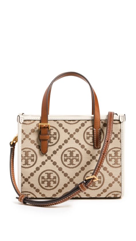 PRICES MAY VARY. Fabric: Canvas Logo monogram pattern, Leather trim with contrast stitching, Structured silhouette Length: 7.5in / 19cm, Height: 6in / 15.5cm, Handle drop: 3.25in / 8cm, Strap drop: 22in / 56cm, Depth: 3.25in / 8.5cm Magnetic clasp Patch interior pocket Stylish and sophisticated, this petite Tory Burch tote is detailed with a jacquard rendition of the label's monogram. Two shades of smooth leather trim add subtle contrast, and an optional crossbody strap provides a convenient fin T Monogram, Tory Burch Tote, Fabric Canvas, Monogram Pattern, S Monogram, Tory Burch Bag, Mini Tote, Monogram Logo, Magnetic Clasp