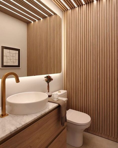 a contemporary neutral bathroom with a wood slat accent wall, a floating vanity, a white sink and a toilet and built in lights Neutral Bathrooms Designs, Monochromatic Living Room, Turkish Tiles, Wood Slat Wall, Restroom Decor, Bathroom Ceiling, Bathroom Design Decor, Wooden Ceilings, White Sink