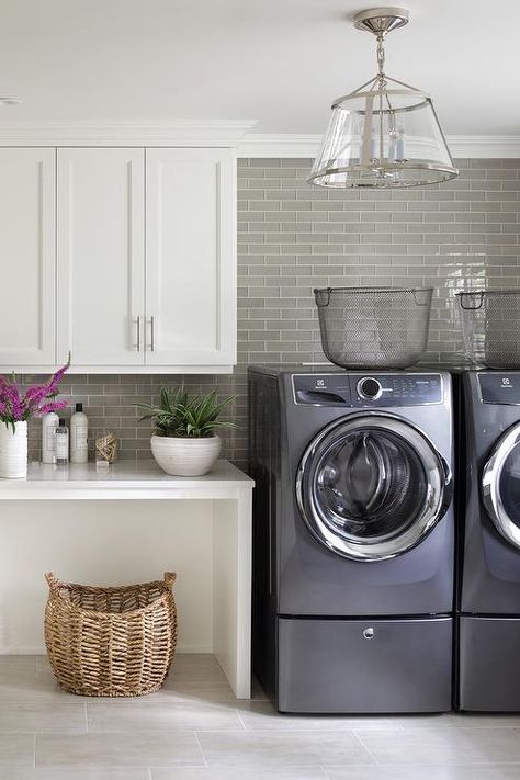 Laundry room with washer and dryer pedestal risers display metal baskets for a vintage touch. Laundry Room Pedestal, Washer And Dryer Pedestal, Room Floor Tiles, Transitional Laundry Room, Laundry Room Storage Shelves, Room Storage Diy, Laundry Room Flooring, Dream Laundry Room, Laundry Room Renovation