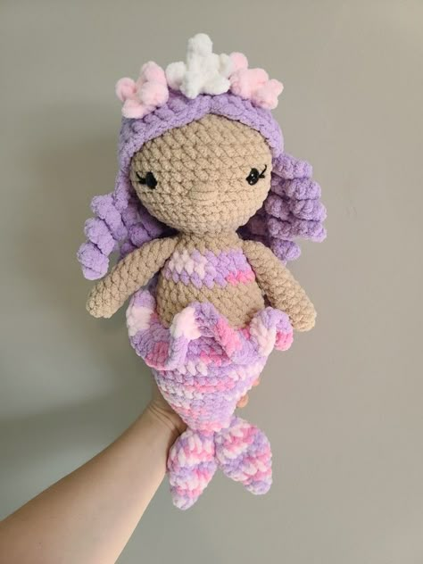 A sweet crochet plushie mermaid with purple, shoulder-length curly hair and 3 flowers on the crown of her head. She has a purple and pink marbled fin with a wavy waist flare to add some fun to her tail. Crochet Mermaid Plushie, Free Crochet Mermaid Pattern, Crochet Mermaid Doll Free Pattern, Crochet Fairies, Crochet Mermaid Pattern, Mermaid Crochet Pattern Free, Crochet Blanket Yarn, Mermaid Crochet Pattern, Mermaid Crochet