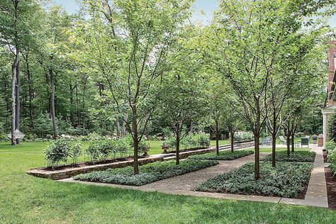 A view from the car barn displays the outdoor terrace and rich grounds highlighted by stone. Modern Orchard Design, Backyard Orchard, Acreage Landscaping, Orchard Design, Massachusetts Boston, Orchard Garden, Country Gentleman, Boston Design, Potager Garden