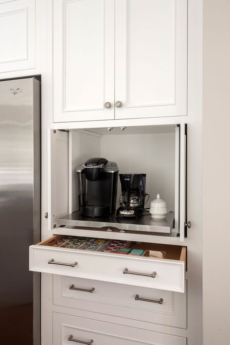 Who doesn’t love their coffee? An appliance garage creates the perfect place to store small appliances such as coffee makers. Add a shallow drawer below and you have the perfect spot to conveniently store your coffee as well!…the perks of custom cabinets. Design by Evalia Design LLC #KountryKraft #CustomCabinetry #ApplianceGarage #designinspiration #cabinetdesign #whitecabinets #customcabinets #madeinusa #americanmade #cabinetstorage #storagesolutions #kitchenorganization #kitchencabinets Kitchen With Coffee Station, Hidden Coffee Bar In Kitchen, Coffee Cabinet Station, Built In Coffee Bar Ideas Kitchen, Hidden Coffee Bar, Coffee Bar Pantry, Butler Room, Built In Coffee Bar, Coffee And Tea Bar