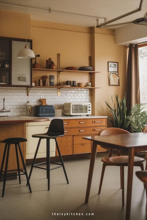 Cozy kitchen with wooden cabinets, plants, and modern bar stools. Retro Modern Kitchen, Ivy Kitchen, Mid Century Modern Kitchen Design, Mid Century Modern Cabinets, Kitchen Dining Ideas, Modern Kitchen Dining, Retro Appliances, Modern Kitchen Design Ideas, Small Apartment Kitchen