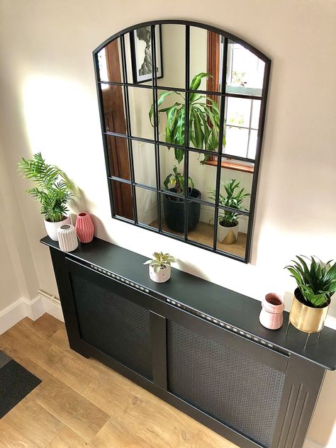 Part of the hallway refurb, I really wanted to cover over the old and tired radiator but felt the a traditional white cover wouldn’t chime with the theme. I found a black version which works really well and allows me to feed my habit of changing up the bits and pieces that sit on top! I’d also coveted this style of window mirror for some time and finally found one in the January sale, it sits opposite a window so bounces the light in this space nicely #hallwaydecor #hallway #hallwayinspo #en Black Metal Console Table, Arched Window Mirror, Entrance Hall Decor, Wood Mirrors, Hallway Mirror, Black Mirror Frame, Black Console Table, Narrow Hallway Decorating, Hallway Designs