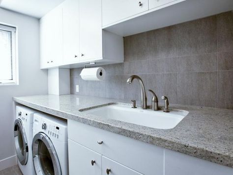 View this Scandinavian laundry room that features a sleek gray backsplash and a functional folding counter on HGTV Remodels. Counter Over Washer And Dryer, Small Laundry Room With Sink, Scandinavian Laundry, Scandinavian Laundry Room, Laundry Room With Sink, Laundry Room Countertop, Grey Laundry Rooms, Kitchen Towel Rack, Gray Backsplash