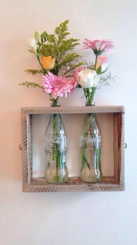 Pallet wood and glass coke bottles used to create a wall mounted vase! Coke Bottle Crafts, Vases Decor Bedroom, Glass Coke Bottles, Garden Boutique, Wall Mounted Vase, Crafty Decor, Diy Wand, Coke Bottle, Diy Dollar Store Crafts