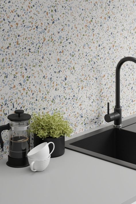 This kitchen worktop and sink shot features a key catching splashback using Spectra Chip from the Axiom by Formica Group laminate worktop collection. Spectra Chip is inspired by the terrazzo tiles of the Mediterranean. This version features blue, green and tan-brown chips on a white background.