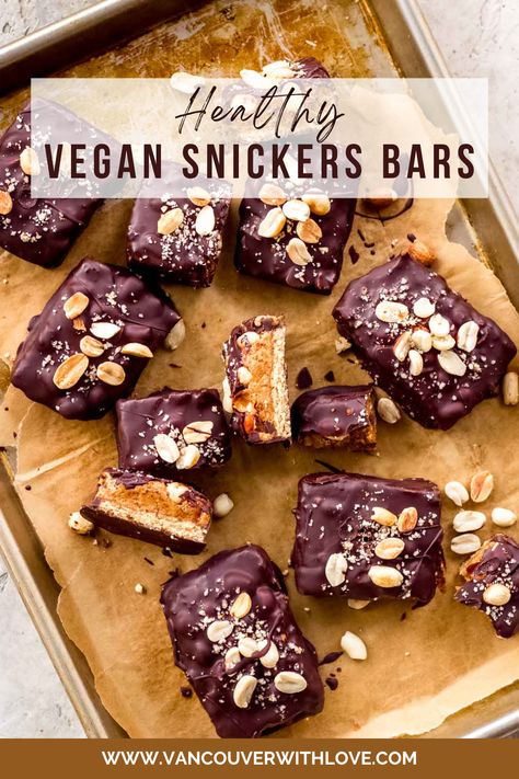 Baking sheet covered in parchment paper with lots of vegan snickers bars scattered over, topped with peanuts. Raw Snickers Slice, Date Snickers, Raw Snickers, Homemade Snickers Bars, Vegan Snickers, Patisserie Vegan, Date Caramel, Homemade Snickers, Raw Vegan Desserts