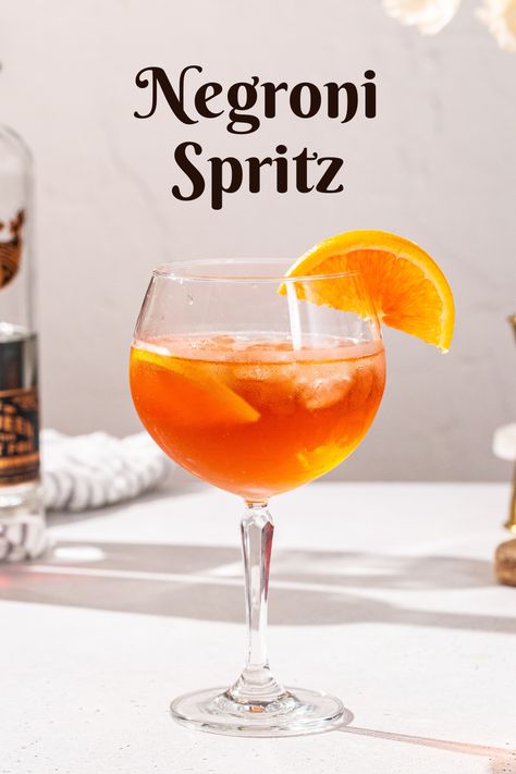 Slightly overhead view of a Negroni Spritz in a stemmed cocktail glass with orange slices as garnish. Text overlay at the top says “Negroni Spritz”. Spritz Bar, Non Alcoholic Champagne, Vermouth Cocktail, Yummy Summer Drinks, Negroni Cocktail, Spritz Cocktail, Sweet Vermouth, Italian Cocktails, Easy Cocktail