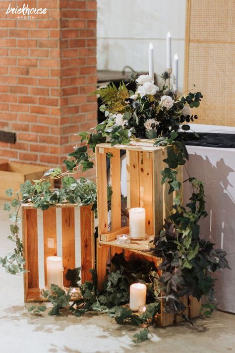 Wooden elevations with candles and fresh foliage to set the mood at the wedding entrance. Rustic Church Wedding, Wedding Entrance Table, Wooden Crates Wedding, White Wedding Flowers Centerpieces, Flower Centrepieces, Wedding Crates, Elegant Black And White Wedding, Wedding Ceiling Decorations, Wedding Reception Entrance