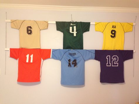 Simple way to hang jerseys as wall art using 1x2s chains and hooks. Plenty of room to expand to another row. Jersey Hanger, Old Football Shirts, Sports Room Boys, Soccer Room, Football Bedroom, T-shirt Display, Teenage Boy Room, Jersey Display, Baseball Room