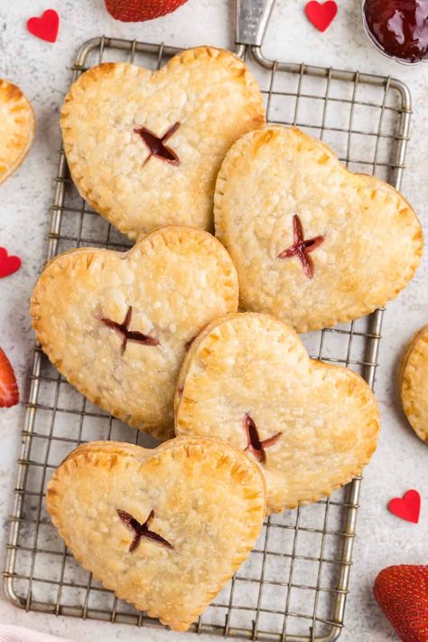 Valentine's Day is just around the corner, and what better way to celebrate than with delicious and easy-to-make desserts? With our Strawberry Cream Cheese Hand Pies, you can enjoy a sweet treat without all the fuss. These pies are made with a cream cheese-based filling and a strawberry compote and can be served warm or cold. Follow us for more easy and delicious recipes that are perfect for any special occasion. Heart Pastries, Cherry Hand Pies Recipes, Strawberry Hand Pies, Sour Cherry Pie, Cherry Hand Pies, Homemade Pie Crust Recipe, Hand Pie Recipes, Homemade Baking, Strawberry Cream Cheese