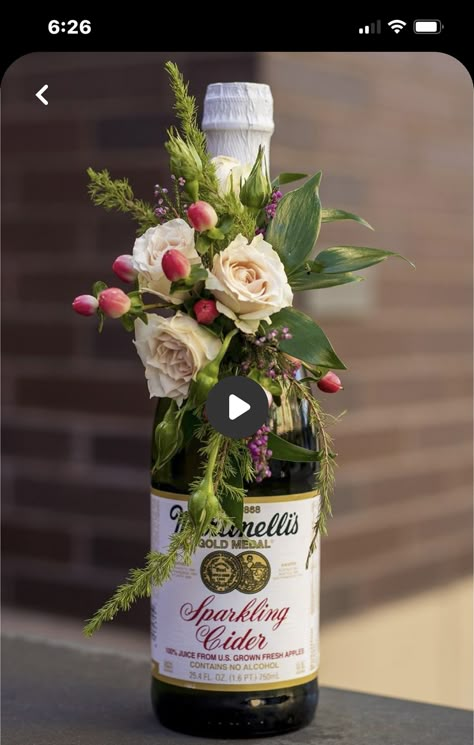 Centerpieces With Bottles, Floral Wine Bottle Centerpieces, Pretty Finger Foods For Party, Floral Arrangements With Wine Bottles, Bridal Shower Wine Bottle Centerpieces, Flowers Around Wine Bottle, Fresh Flowers On A Wine Bottle, Corsage Box Ideas, Wine Bottle With Flowers Centerpieces