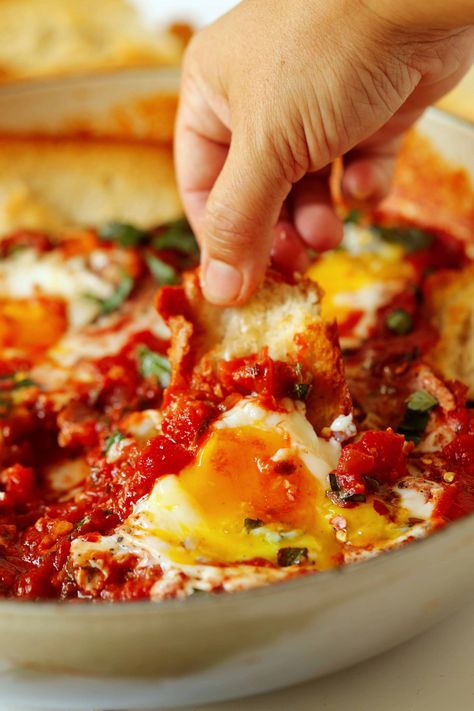 A hand dipping a piece of baguette into a pan of Eggs In Purgatory. Spicy Breakfast, Eggs In Purgatory, Brunch Sides, Pan Seared Steak, Italian Chopped Salad, Italian Breakfast, Brunch Casserole, Spicy Tomato Sauce, Bar Food