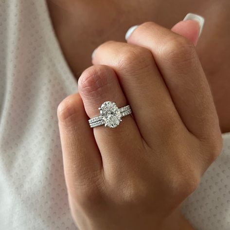 This exquisite engagement ring set showcases a brilliant 2-carat oval lab-grown diamond, complemented by the shimmering beauty of pave-set diamonds. The oval diamond radiates exceptional quality with its brilliant cut facets, while the hidden halo design frames it with smaller accent diamonds, creating a mesmerizing effect. The band itself is adorned with pave diamonds, adding a sparkling brilliance that enhances the ring's overall allure. Each diamond is securely set in a shared prong setting, maximizing their brilliance with optimal light reflection. To complete the set, a matching pave wedding band perfectly complements the elegance of this stunning engagement ring. The bridal set contains 2 rings : ------------------------------------------------------------- Engagement Ring Details : Weeding Ring Oval, 2 Carat Oval Engagement Ring And Wedding Band, Oval Wedding Ring Set Stack White Gold, Oval Engagement Ring With Halo And Band, Oval Ring With Thick Band, Pave Oval Engagement Ring With Wedding Band, Wedding Band With Oval Diamond, White Gold Oval Engagement Ring Set, Oval Engagement Ring With Diamond Band Wedding Set