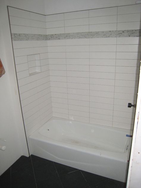 4x16 with schluter strips edge...not sure I'm ok with this look. Maybe painted strips to match wall? Schluter Tile Edge, White Subway Tile Shower, Tile Tub Surround, Patterned Bathroom Tiles, Subway Tile Showers, Subway Tiles Bathroom, Ceramic Subway Tile, Bath Tiles, White Bath