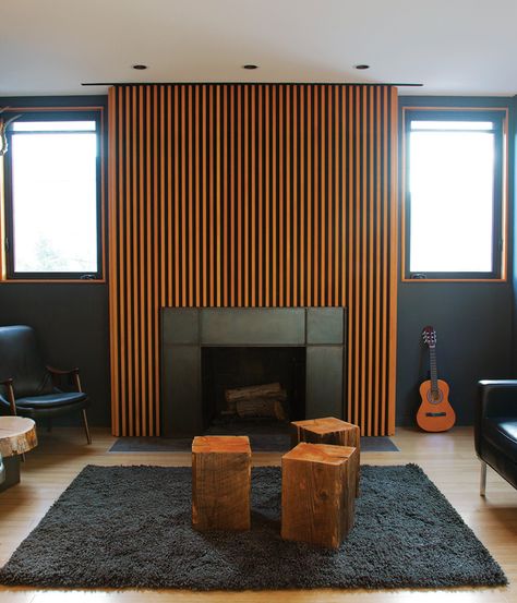 A series of Douglas fir slats was applied above the fireplace.  Photo by Zen Sekizawa. Chimney Decor, Dark Living Rooms, Dark Walls, Dark Interiors, Wood Fireplace, Modern Fireplace, Fireplace Mantle, Living Room With Fireplace, Fireplace Design