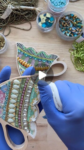 Sharra Frank on Instagram: "Oh, grout… the glamorous side of mosaics.😆
Here are some tips & encouragement! ⬇️

Grouting textured mixed media mosaics doesn’t have to be all or nothing. Consider focusing on areas of importance, avoiding sections that are perhaps better off without it (here, I left the beads and rhinestones). 

It’s a work of art, not a kitchen floor! 🙃 So we get to call the shots. In this piece I only grouted two specific sections where I used china.

In this mosaic the grout is an aesthetic choice, the durability and longevity are not dependent on grout (not the case in all mosaics). Here, it’s just providing a finishing touch. ✨

I often “spot grout” using the clipped corner of a ziplock baggie, addressing specific areas to fill deeper crevices, softening shadows and bri Sharra Frank Mosaics, Grouting Mosaics, Bead Mosaic, Mixed Media Mosaic, Shell Mosaic, An Aesthetic, Kitchen Floor, All Or Nothing, I Left