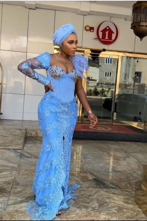 A lady wearing a skyblue lace material Sky Blue Asoebi Lace Styles, Sky Blue Asoebi, Blue Asoebi Lace Styles, Lace Gown Styles 2023, Classy Asoebi Lace Styles, Blue Asoebi, Wedding Asoebi Styles, Elegant Asoebi Styles, Lace Styles For Women