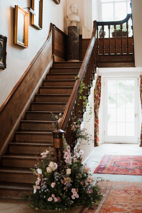 Greenery and pink flowers on staircase bannister for a wedding. Flower Garland Staircase, Staircase Wedding Flowers, Staircase Florals Wedding, Greenery On Staircase, Staircase Flowers Wedding, Staircase Greenery, Staircase Florals, Staircase Flowers, Wedding Staircase Decoration