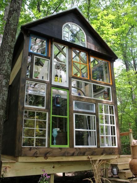 This unique home is covered in colorfully framed windows, flooding it with natural light and creating a magical look. Tiny Luxury, Alternative Homes, Glass Cabin, Tiny House Exterior, Lots Of Windows, Tiny Cabin, Suspension Bridge, Cabin Design, Tiny House Living