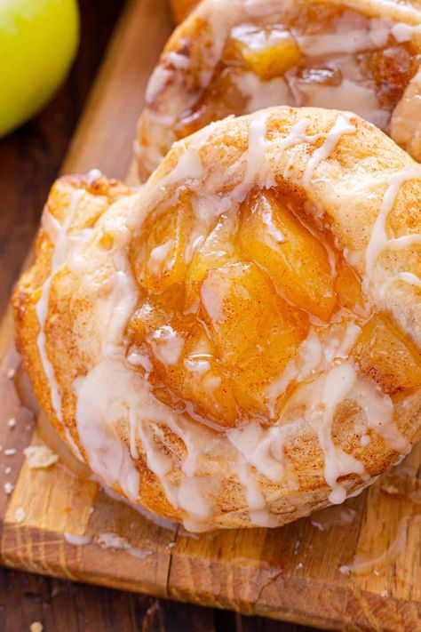 This Apple Danish recipe offers two options for making danishes - with crescent rolls or puff pastry with cream cheese. Both result in an irresistible dessert with apple pie filling and a sweet glaze on top. Easy Apple Danish Recipe, Caramel Apple Danish, Apple And Cream Cheese Danish, Apple Breakfast Pastries, Pineapple Danish Recipe, Crescent Roll Recipes Apple, Crescent Roll Donut Recipes, Apple Cream Cheese Puff Pastry, Crossaint Dessert Ideas